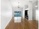 Spacious living room with hardwood floors, a large window overlooking the pool, and a modern chandelier at 4993 Heatherstone Pl, Orlando, FL 32812