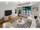Bright living room featuring a large window, hardwood floors, and stylish modern furniture at 4993 Heatherstone Pl, Orlando, FL 32812