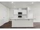 Bright kitchen with white cabinets, modern appliances, a breakfast bar and a view into an adjacent room at 5111 Marshelder St, Apopka, FL 32712