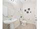 Clean, well-lit powder room featuring a pedestal sink and decorative wall art at 5156 Oakbourne Ave, Davenport, FL 33837