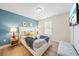 Stylish bedroom with a queen bed, blue accent wall, and cozy decor at 5156 Oakbourne Ave, Davenport, FL 33837