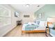 Bright bedroom with two windows, a desk area, and a queen bed dressed in blue and white at 5156 Oakbourne Ave, Davenport, FL 33837