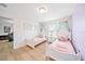 Charming bedroom with two white twin beds adorned with pink bedding and canopy details at 5156 Oakbourne Ave, Davenport, FL 33837