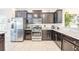 Modern kitchen featuring stainless steel appliances, dark cabinetry, and granite countertops at 5156 Oakbourne Ave, Davenport, FL 33837