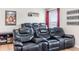 Home theater room with plush seating, a media center, and movie-themed décor at 5156 Oakbourne Ave, Davenport, FL 33837