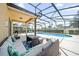 This screened-in pool area features seating and grill, perfect for entertaining at 5156 Oakbourne Ave, Davenport, FL 33837