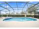 Screened-in pool and spa with patio and surrounding landscaping at 5156 Oakbourne Ave, Davenport, FL 33837