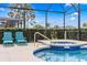 Screened-in pool with spa and poolside seating under blue skies at 5156 Oakbourne Ave, Davenport, FL 33837