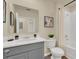 Modern bathroom with gray vanity, white countertop, large mirror, white toilet, and shower-tub combo at 5282 Scrub Mint Ln, Apopka, FL 32712