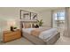 Comfortable bedroom with neutral tones, a queen bed, a nightstand, and a window providing natural light at 5282 Scrub Mint Ln, Apopka, FL 32712