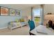 Bright bedroom featuring twin bed, desk, blue accent wall, and natural light from the window at 5282 Scrub Mint Ln, Apopka, FL 32712