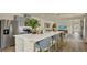 Spacious kitchen with gray cabinets, stainless steel appliances, white countertop island with seating, and wood floors at 5282 Scrub Mint Ln, Apopka, FL 32712