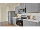 Contemporary kitchen features stainless steel appliances, subway tile backsplash and stylish gray cabinetry at 5282 Scrub Mint Ln, Apopka, FL 32712