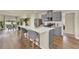 Contemporary kitchen featuring a large island with seating, stainless steel appliances, and wood floors at 5290 Scrub Mint Ln, Apopka, FL 32712