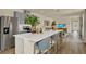 Modern kitchen with stainless steel appliances, a large island with chairs, and wood flooring at 5290 Scrub Mint Ln, Apopka, FL 32712