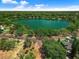 Aerial view of a serene lake surrounded by lush trees and residences, showcasing a tranquil community at 604 Cherokee Dr, Orlando, FL 32801