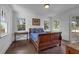 Serene bedroom featuring a wood bed, hardwood floors, and three large windows at 604 Cherokee Dr, Orlando, FL 32801