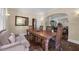 A dining room with a large wooden table and seating for six, offering a view into the living room at 604 Cherokee Dr, Orlando, FL 32801