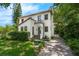 A charming home features a red tile roof, balcony, and a brick driveway, surrounded by mature trees at 604 Cherokee Dr, Orlando, FL 32801