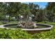 Scenic fountain with whimsical statuary surrounded by lush greenery and mature trees at 604 Cherokee Dr, Orlando, FL 32801