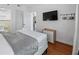 Bright bedroom featuring a large wall-mounted TV and hardwood floors at 6165 Carrier Dr # 1304, Orlando, FL 32819