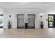 Building lobby with elevators, tile floor, plants, and decor at 6165 Carrier Dr # 1304, Orlando, FL 32819