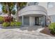 Inviting building entrance with palm trees, mature plants and covered entry at 6165 Carrier Dr # 1304, Orlando, FL 32819