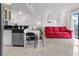 Cozy open living space combining a living room with a red couch and an adjacent kitchen with a breakfast bar at 6165 Carrier Dr # 1304, Orlando, FL 32819