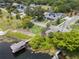 A bird's eye view of a modern home featuring a private boat dock, with lush landscaping and mature trees at 705 N Lake Sybelia Dr, Maitland, FL 32751