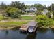 An aerial view of a modern two-story home with a private boat dock, situated on a picturesque waterfront lot at 705 N Lake Sybelia Dr, Maitland, FL 32751