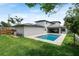Aerial backyard featuring modern home, pool, paver deck, green grass, and mature trees at 705 N Lake Sybelia Dr, Maitland, FL 32751