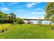 Lush backyard with well-maintained lawn and landscaping overlooking the lake and a covered boat dock at 705 N Lake Sybelia Dr, Maitland, FL 32751