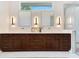 Spacious bathroom features a double sink vanity with white countertops, wood cabinets, and decorative lighting at 705 N Lake Sybelia Dr, Maitland, FL 32751