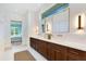 Bright bathroom featuring a double vanity, sleek countertops, and modern lighting fixtures at 705 N Lake Sybelia Dr, Maitland, FL 32751