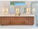 Bright bathroom showcasing a long vanity with dual sinks, stylish mirrors and designer lighting at 705 N Lake Sybelia Dr, Maitland, FL 32751