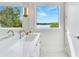 Clean bathroom with marble floors, white vanity, and views of the water at 705 N Lake Sybelia Dr, Maitland, FL 32751