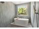 Stylish freestanding tub with a shower and tiled walls, for a serene experience at 705 N Lake Sybelia Dr, Maitland, FL 32751