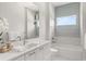 Bright bathroom with double sinks, stylish tile accent wall and soaking tub at 705 N Lake Sybelia Dr, Maitland, FL 32751