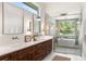 Modern primary bathroom with dual sinks, spacious shower, and soaking tub with a view at 705 N Lake Sybelia Dr, Maitland, FL 32751