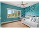 Charming blue bedroom featuring a mural wall and natural light at 705 N Lake Sybelia Dr, Maitland, FL 32751