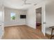 Bedroom with hardwood floors, a television, a bright window, and an open door at 705 N Lake Sybelia Dr, Maitland, FL 32751
