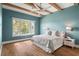Airy bedroom with teal walls, wooden beams, and large window offering a view of the lake at 705 N Lake Sybelia Dr, Maitland, FL 32751