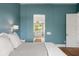 Airy bedroom with teal walls, showing the door to the primary bathroom at 705 N Lake Sybelia Dr, Maitland, FL 32751