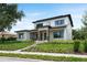 Stunning two-story modern home with manicured lawn and landscaped walkway leading to the front door at 705 N Lake Sybelia Dr, Maitland, FL 32751