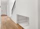 A modern hallway with wood floors features a staircase with sleek metal railings and a storage nook at 705 N Lake Sybelia Dr, Maitland, FL 32751