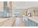 Modern kitchen featuring stainless steel appliances, blue backsplash, and center island with water views at 705 N Lake Sybelia Dr, Maitland, FL 32751