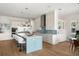 Bright kitchen features a blue island, white cabinets, stainless steel appliances, and pendant lighting at 705 N Lake Sybelia Dr, Maitland, FL 32751