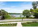 Beautiful view of the lake and dock from the property, enhanced by lush landscaping and a clear sky at 705 N Lake Sybelia Dr, Maitland, FL 32751