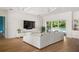 Bright living room with a large sectional sofa, modern entertainment center, and sliding doors to the pool at 705 N Lake Sybelia Dr, Maitland, FL 32751