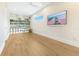 Bright living room with wood floors, built-in bookshelves, and a large TV at 705 N Lake Sybelia Dr, Maitland, FL 32751